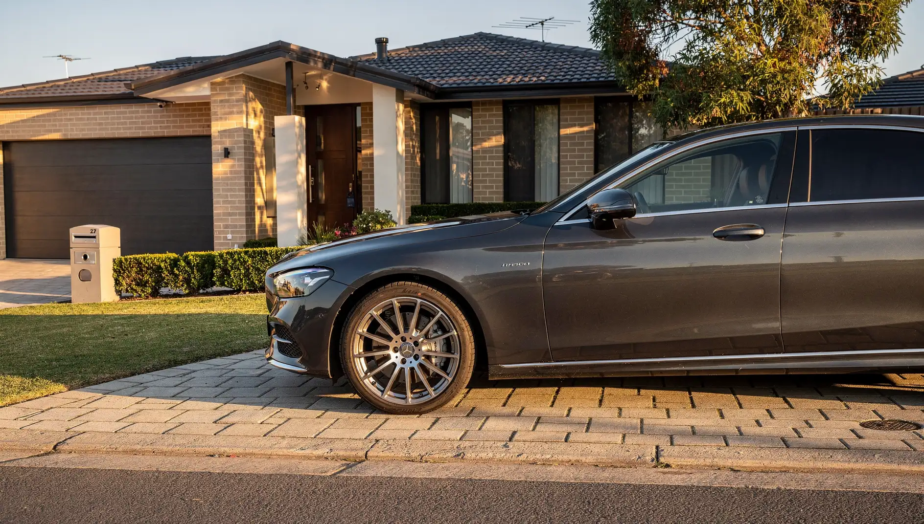 Freshly detailed metallic-graphite luxury saloon with mirror-gloss clearcoat in a Perth driveway.