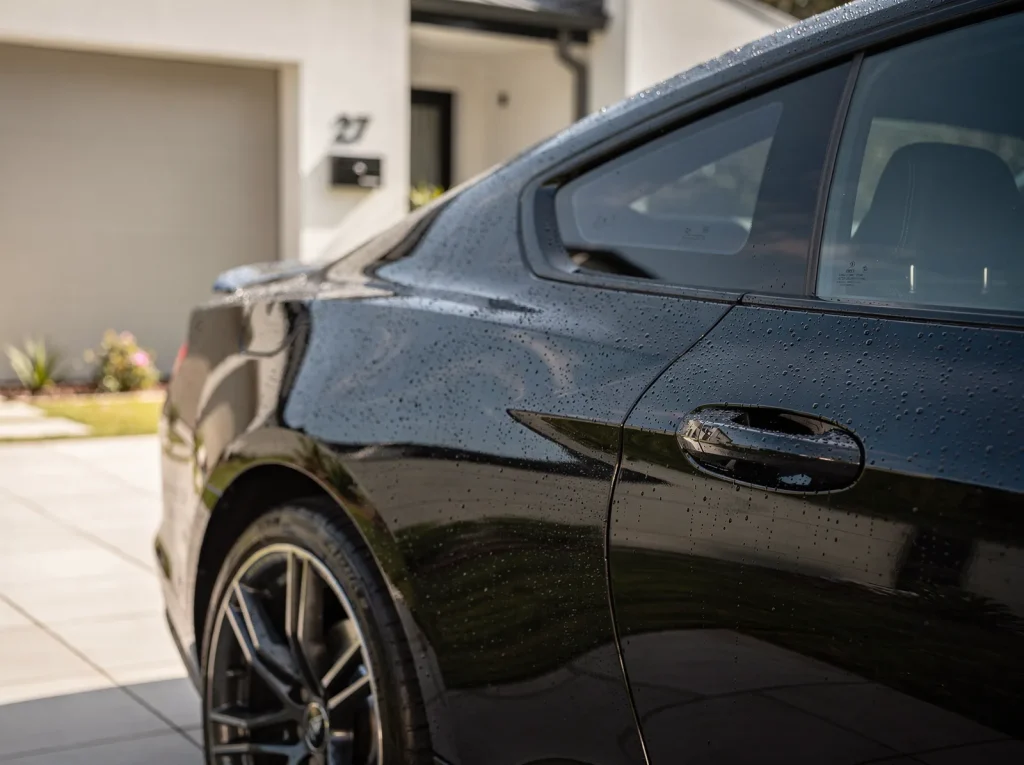 Water beads on glossy swirl-free coupe quarter panel after Perth car detailing.