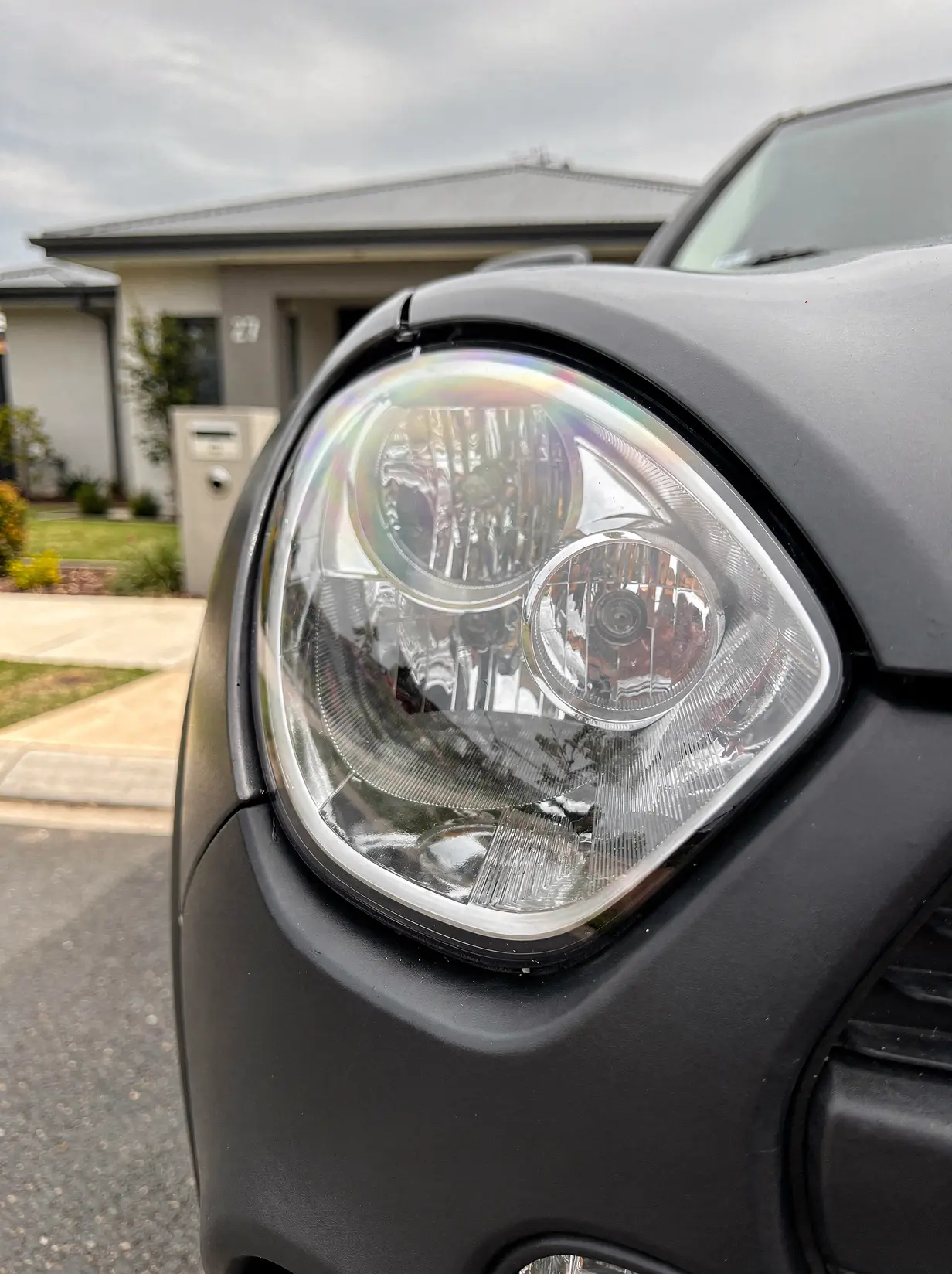 Restored crystal-clear headlight lens with sharp chrome reflectors after Perth car detailing.