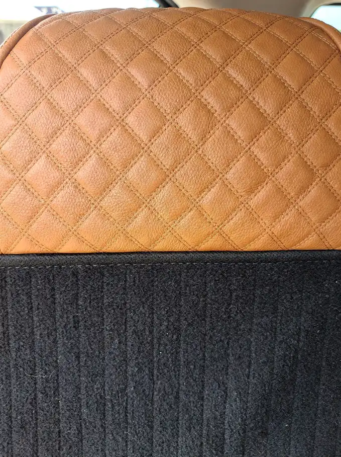 Detailed tan quilted leather seat bolster and vacuumed charcoal carpet in Perth.