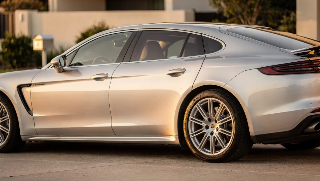 Freshly detailed silver Porsche Panamera on a Perth driveway at golden hour.